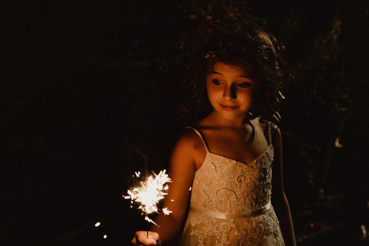A small child holding a sparkler 