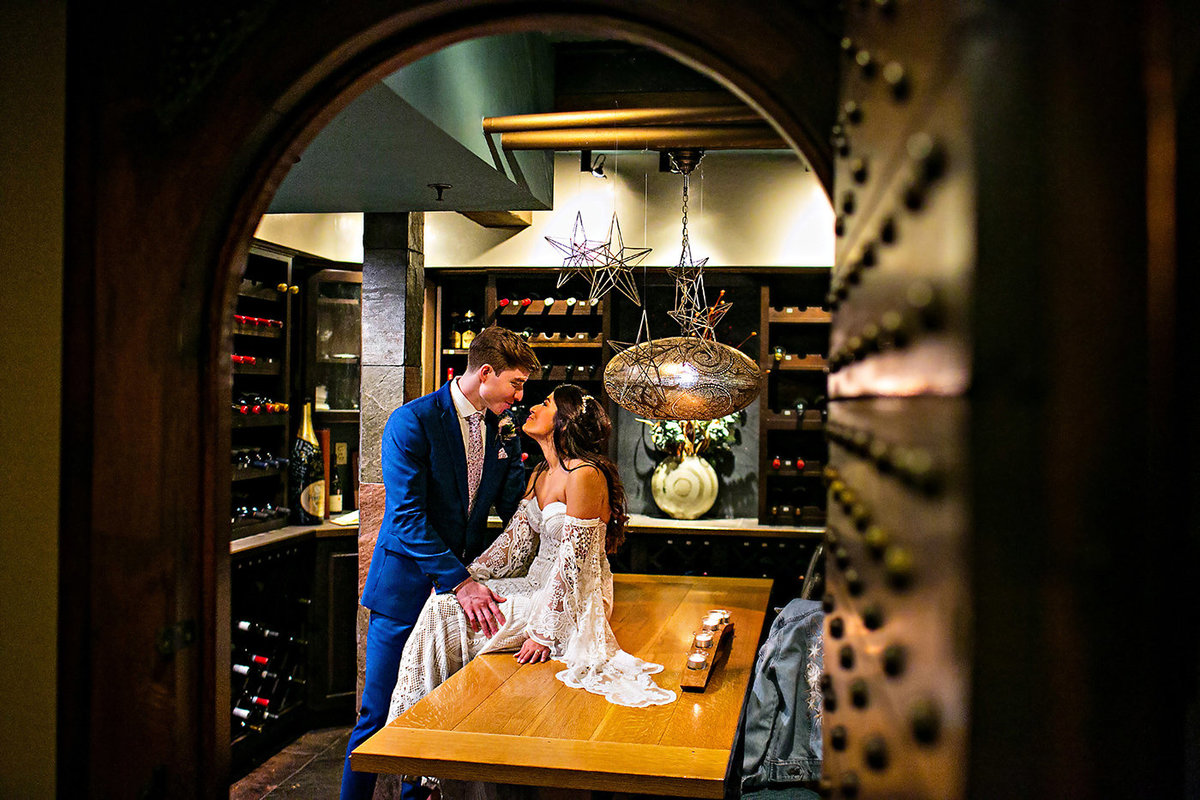 A wedding couple poses in the wine cellar at Gracie's in Providence.