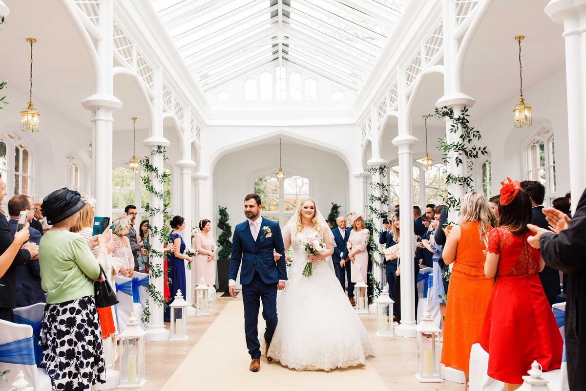 Bride and Groom exiting their wedding ceremony at the beautiful, light and airy orangery at St Audries Park, Somerset.