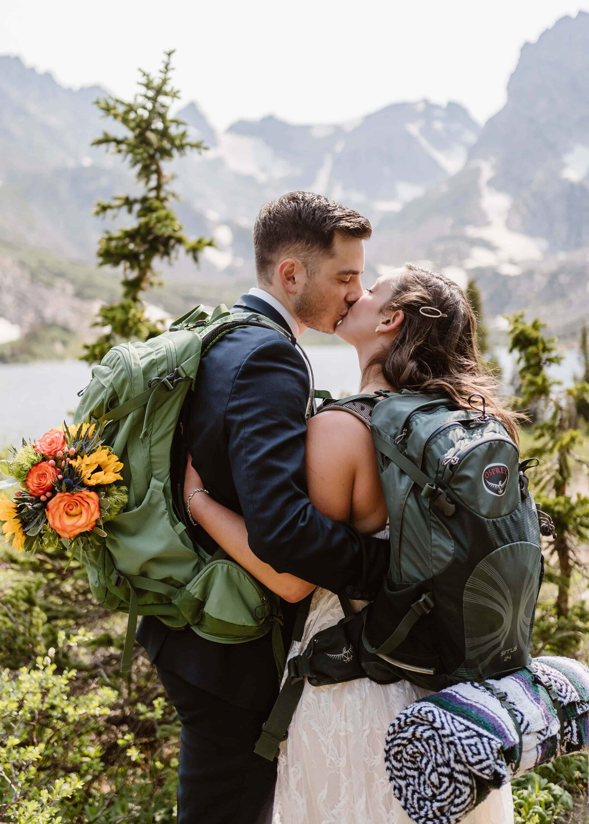 Couple walks hand in hand through a forested mountain path during their Vail, Colorado elopement.
