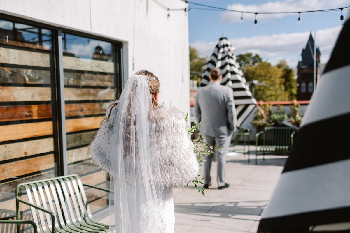Bride walking towards groom for first look on rooftop of Common House Charlottesville wedding