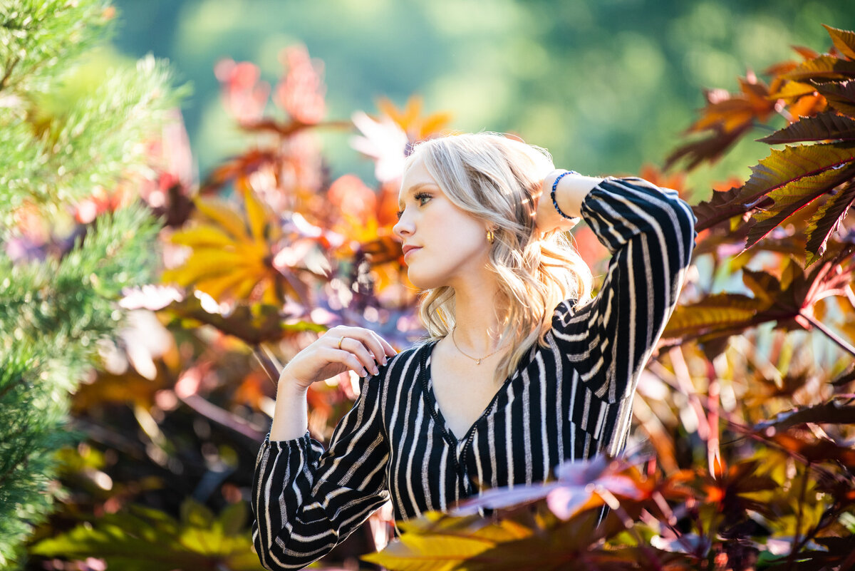 Chaska Minnesota high school  senior photo of girl in striped jumpsuit in colorful leaves
