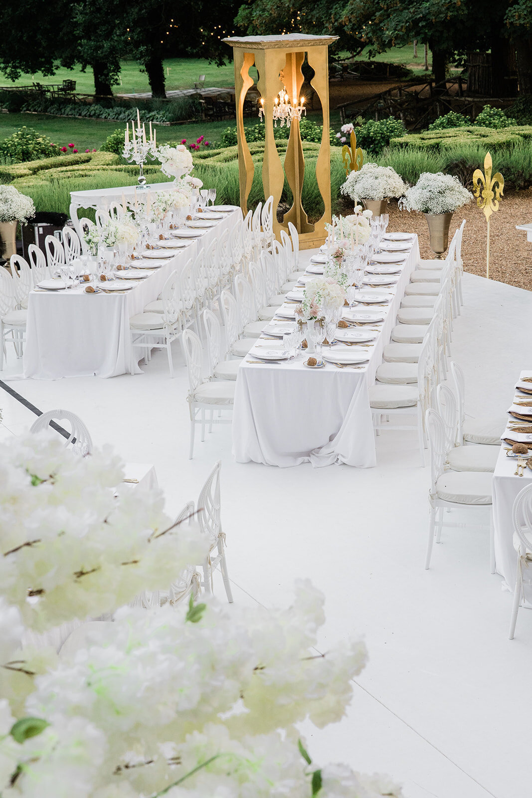 Beautifully arranged outdoor wedding dinner table for a summer wedding at Château Challain, captured in elegant, romantic fine-art photography.