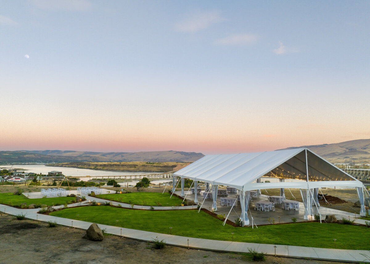 White tent installed in a green grass at Celilo