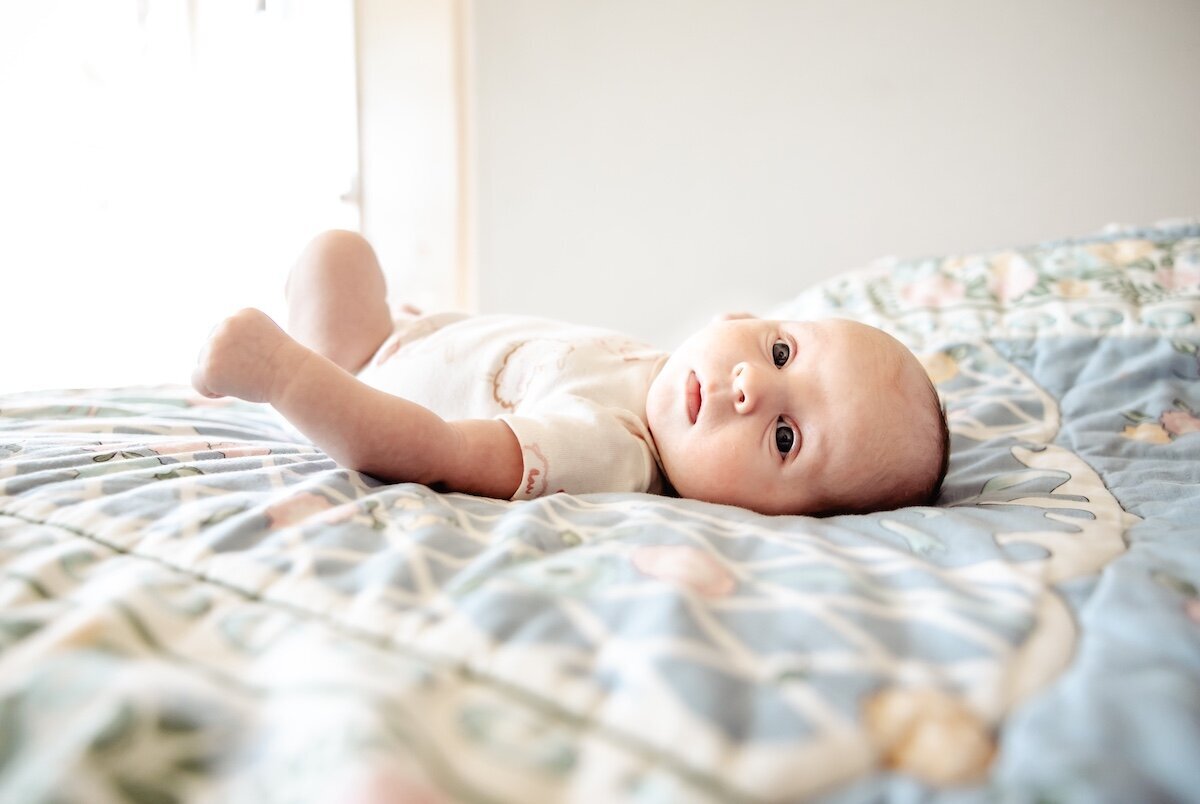 A newborn baby girl wearing a sheep onesie