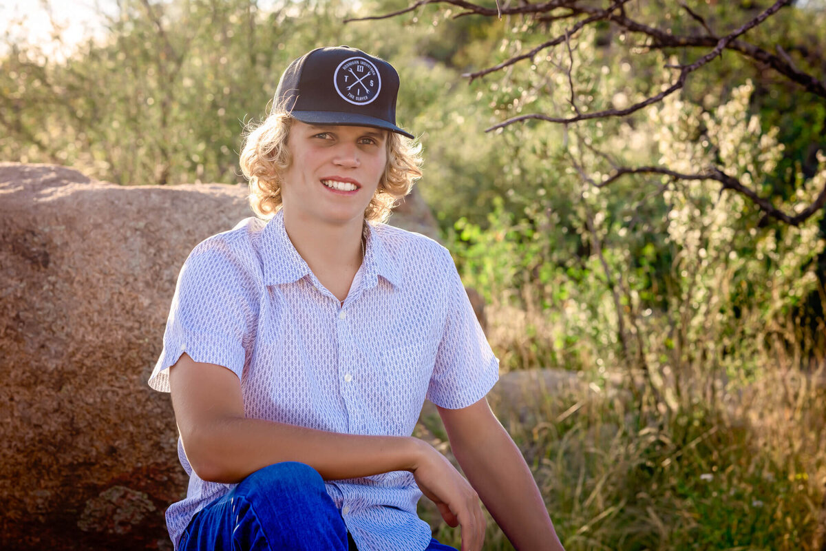 Boy poses on a rock in Prescott senior photography session