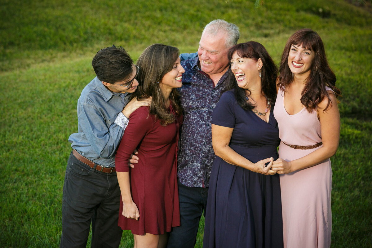A family of five all standing together smiling