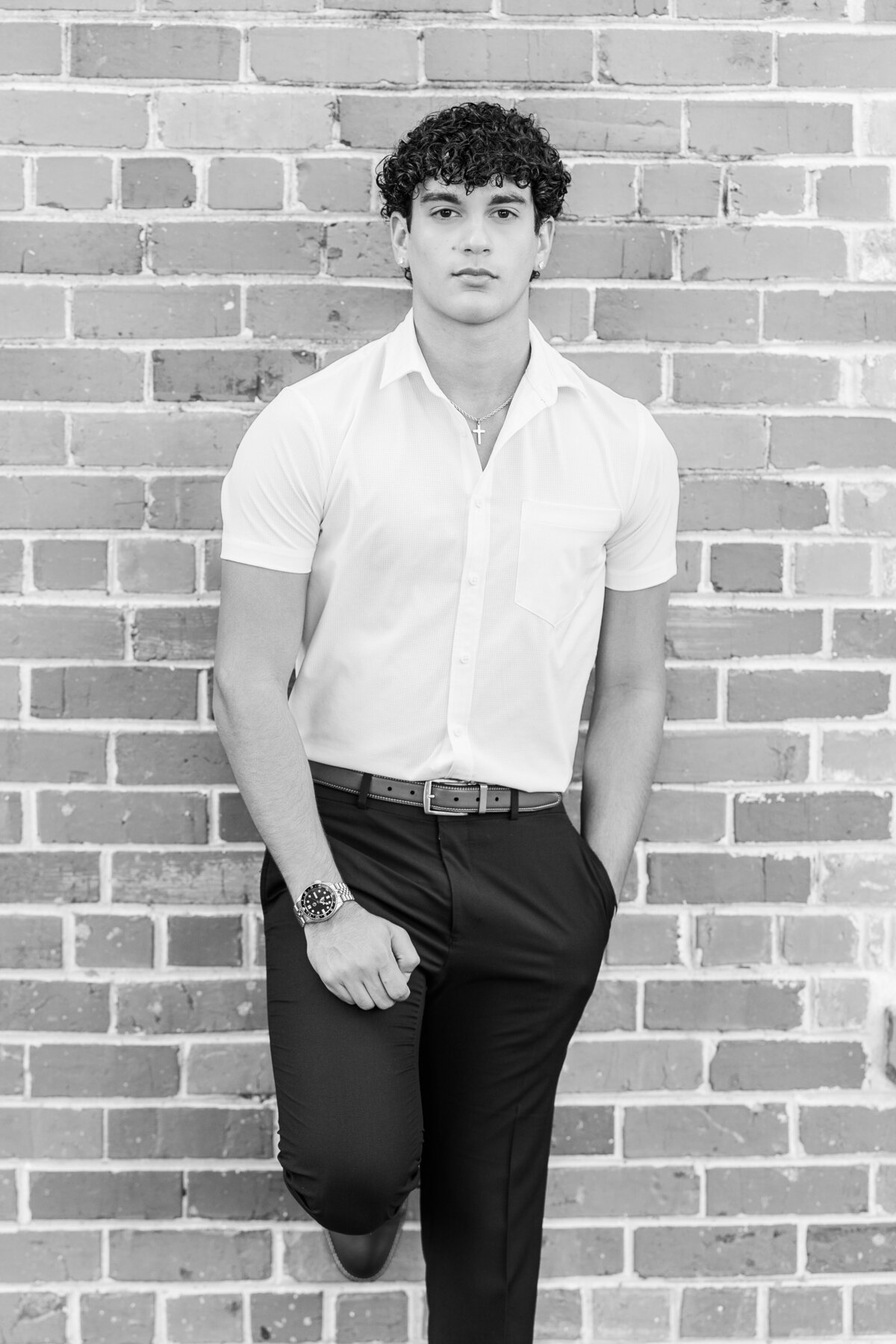 A confident senior portrait featuring clean lines and classic styling, taken against a vintage brick wall in downtown Fort Worth. A polished, masculine image by Jennifer Lynn Photography.