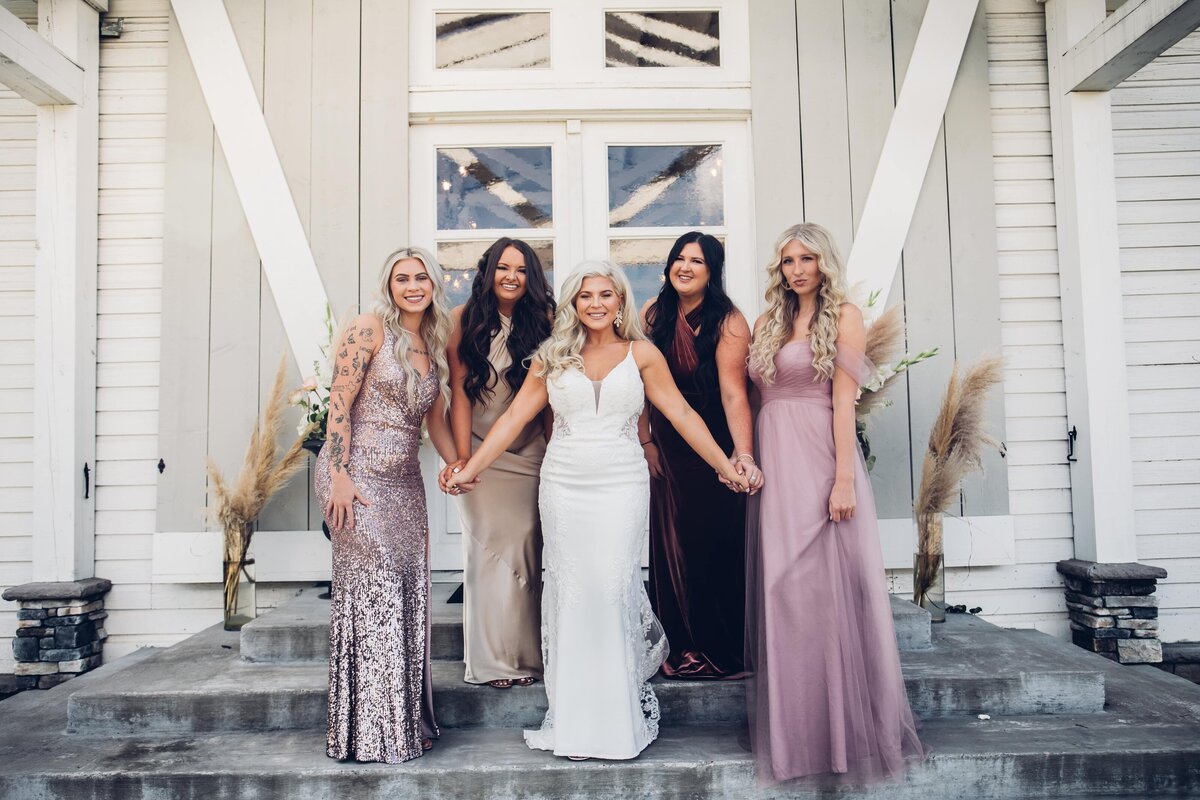 A group of bridesmaids, captured beautifully by a Shreveport wedding photographer, strike a pose on the steps of a house during this joyful moment. This stunning image showcases the talent and expertise of a