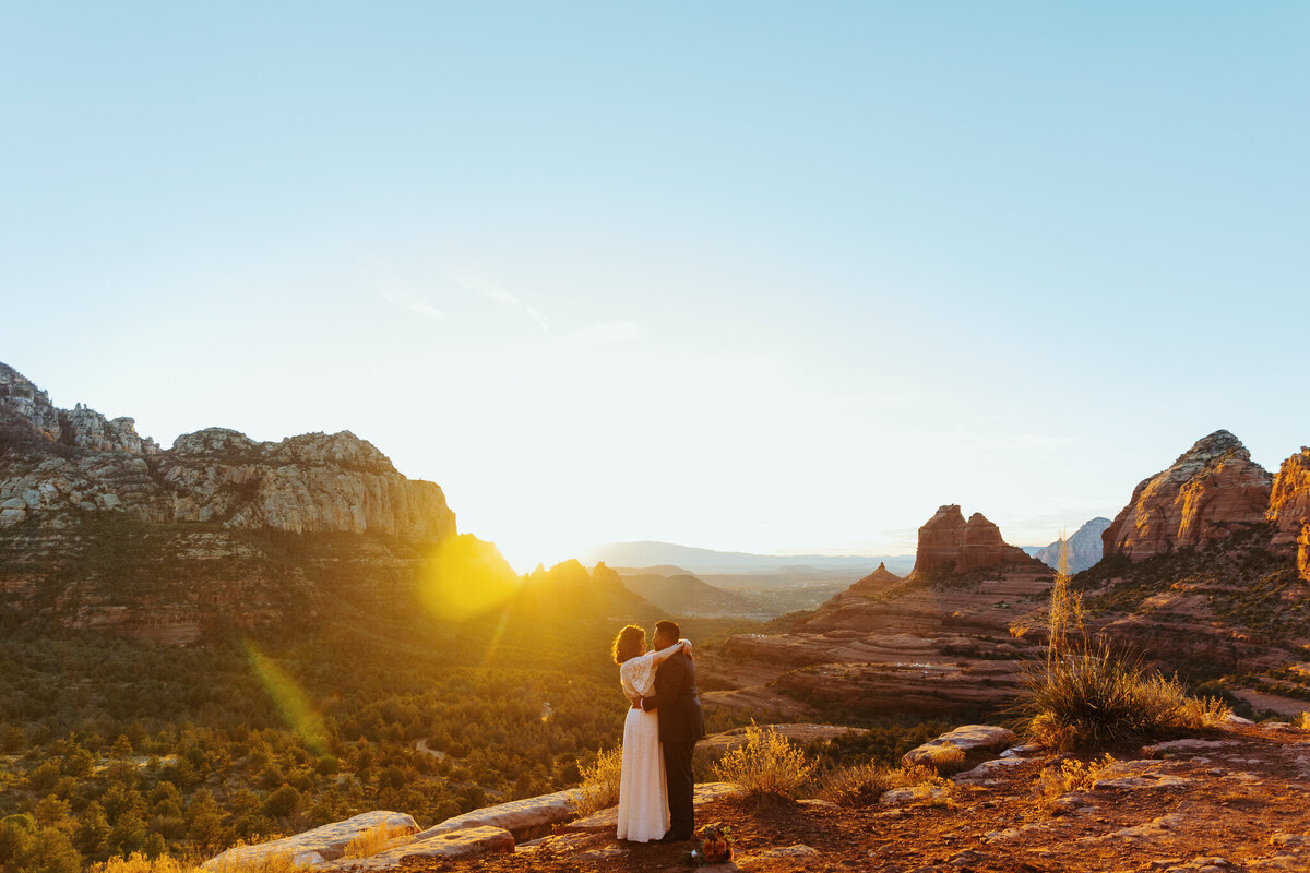 man and woman stand together with sedona backdrop at merry go round rock in sedona