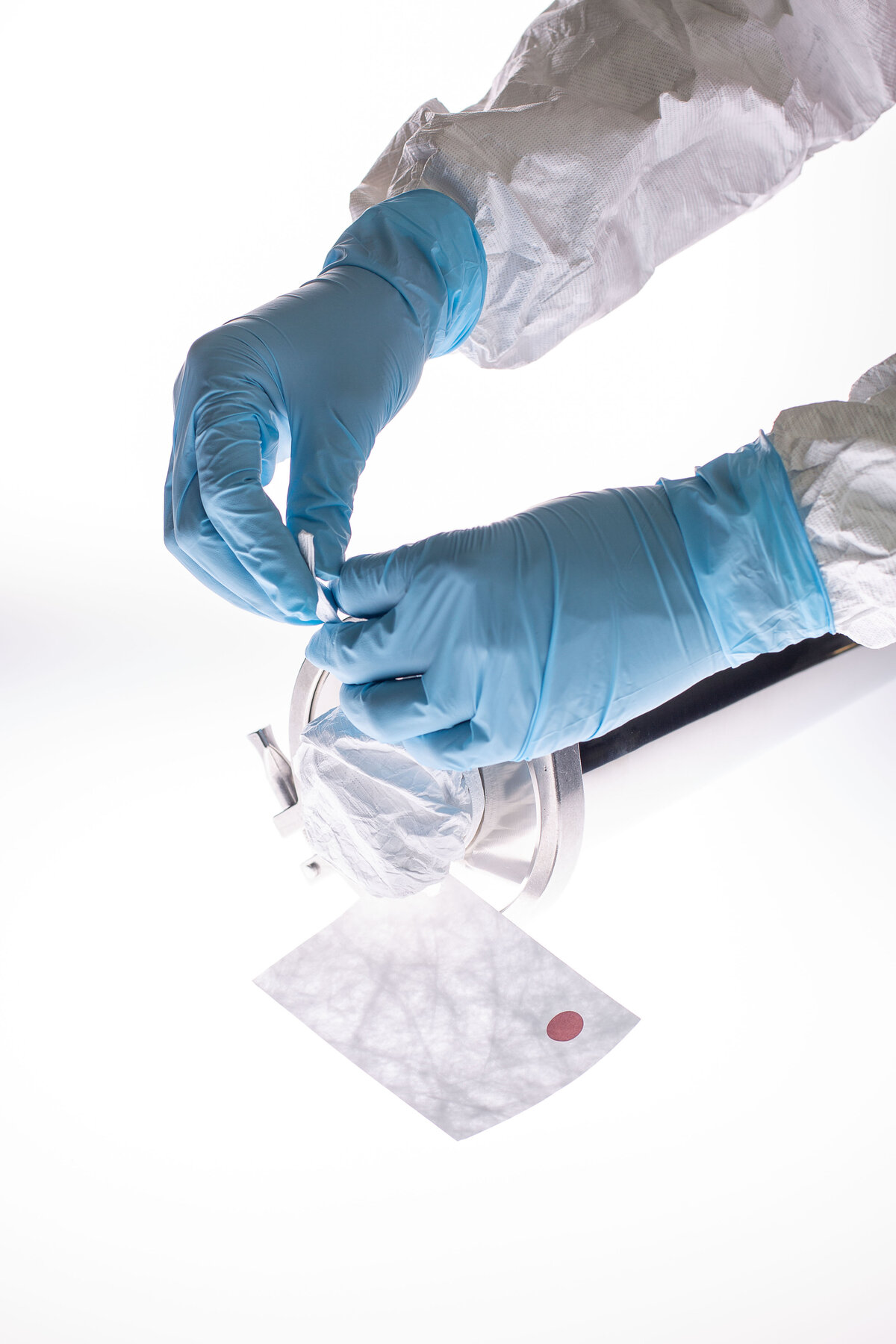 Gloved hands covering a piece of equipment