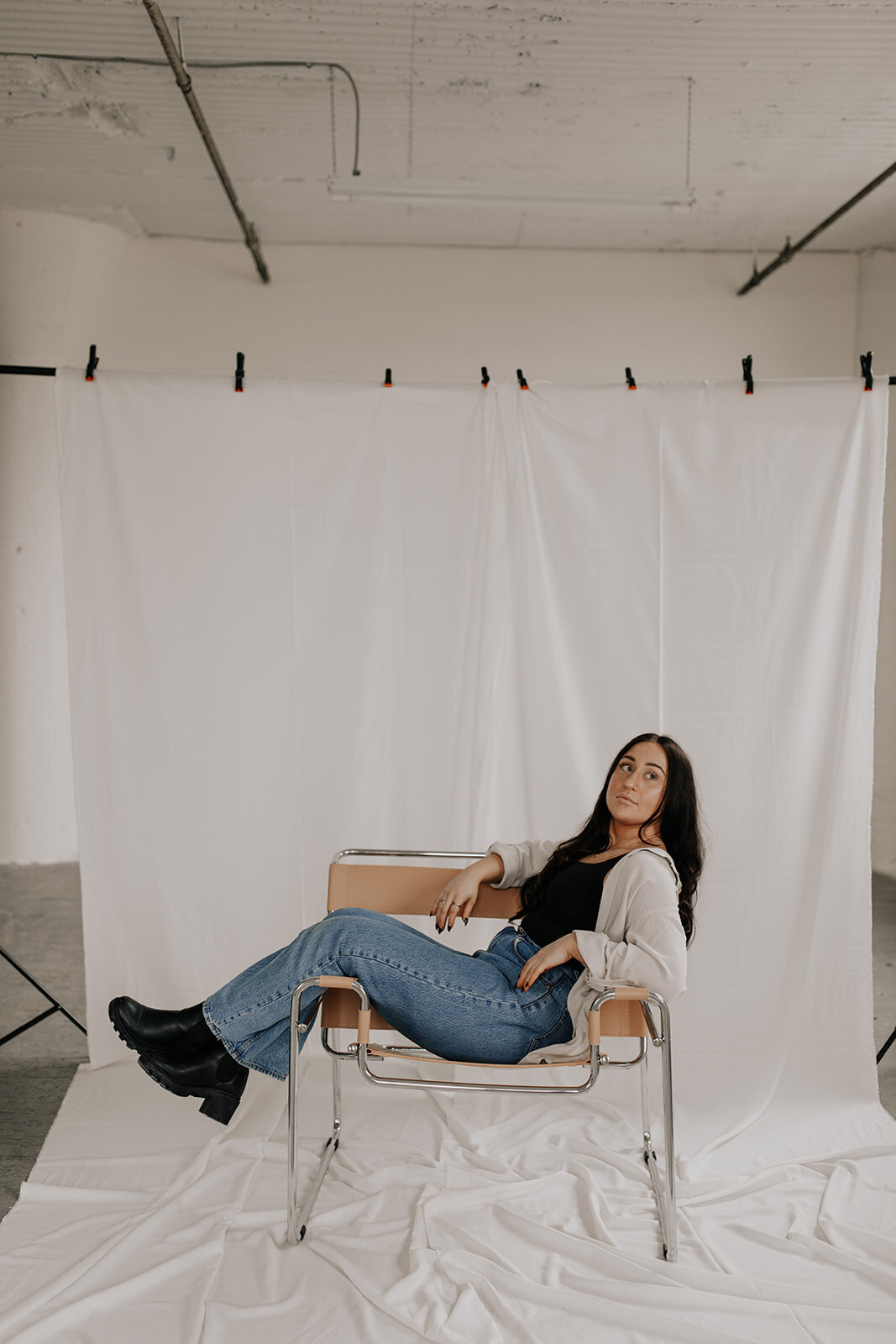 Photoggrarpher sits in a chair posing during a studio session