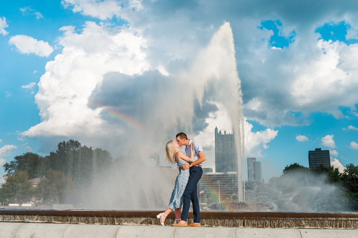 couple celebrating after they got engaged in picture by point state park fountain