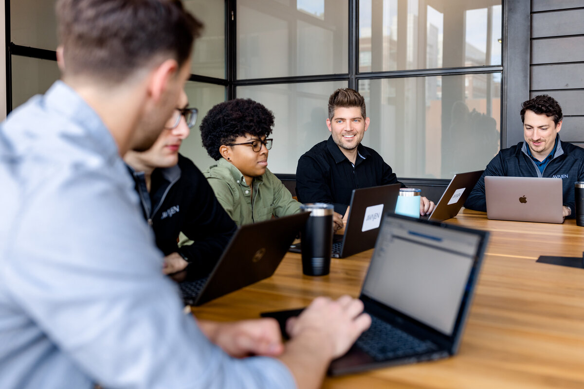 IT Team in Denver talks around table for lifestyle branding photos