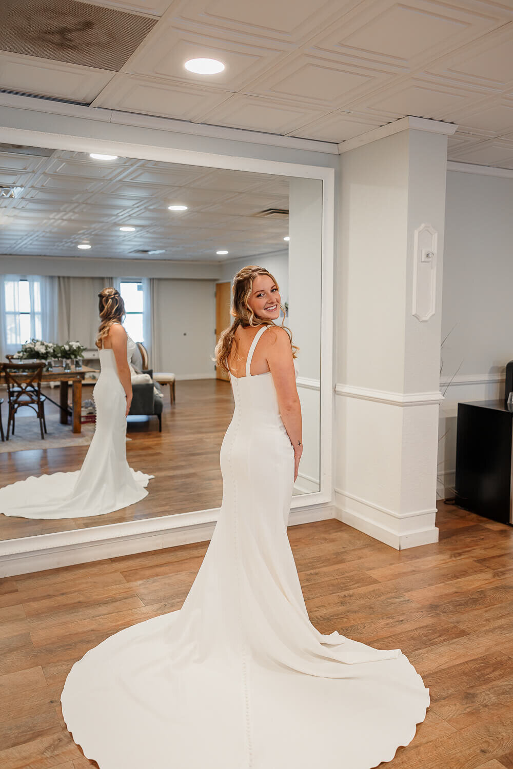 Portrait of the bride in her wedding dress looking behind her and smiling. Photo taken in Colorado Springs, Colorado