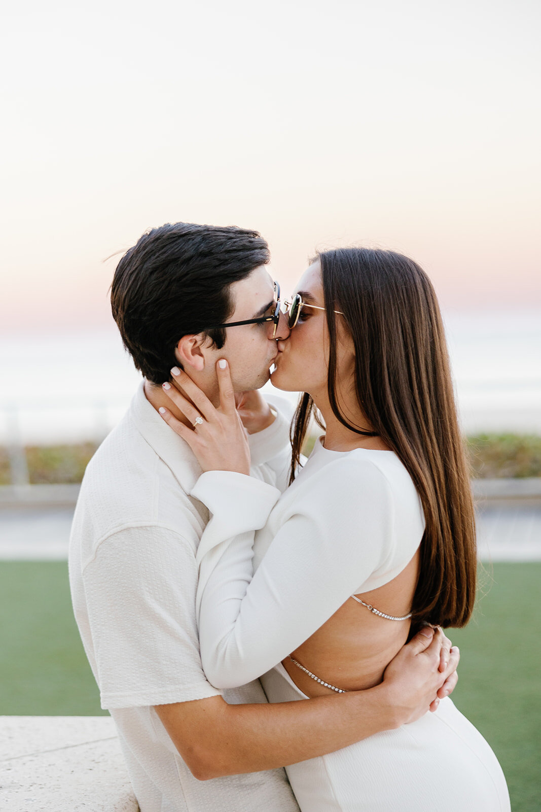 Rebecca and Graysen share a romantic kiss against a breathtaking pastel sunset at Marriott Hotel Fort Lauderdale, their stylish engagement session beautifully captured by Claudia Amalia Photography.