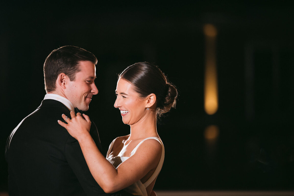Bride and groom sharing a joyful first dance under evening lights, beautifully captured by Arizona wedding photography team.