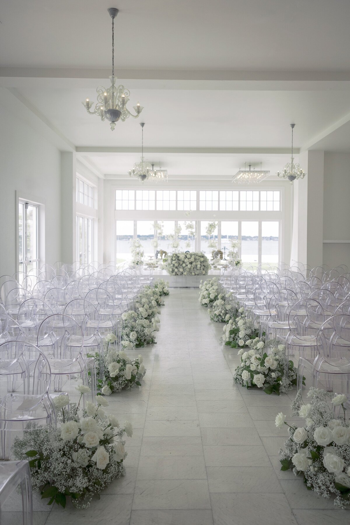 Clear chairs with cream flors aisle decor at Belle Mer Newport. 