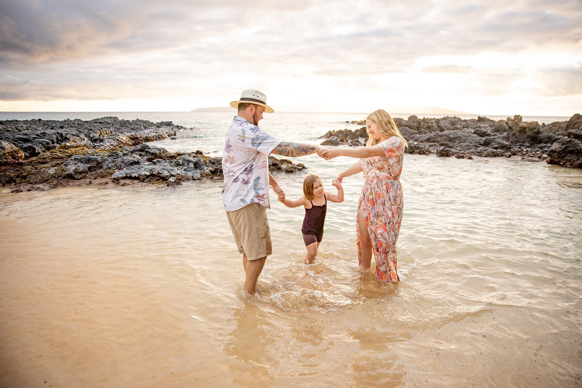 Maui Family Photographers capture young family playing in water together during family beach photos in Maui