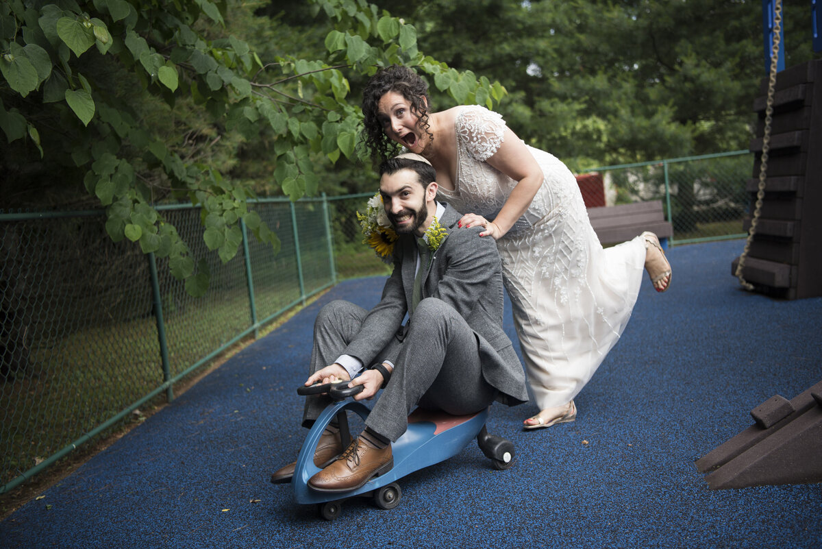 A person pushing their partner on a small sled on their wedding day 