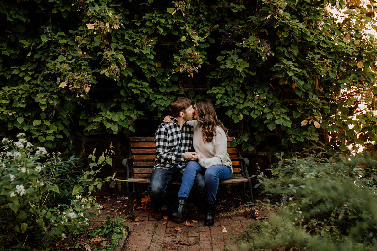 Bride and groom holding hands looking at each other while standing in front of rolling hills with the sunlight coming down on them