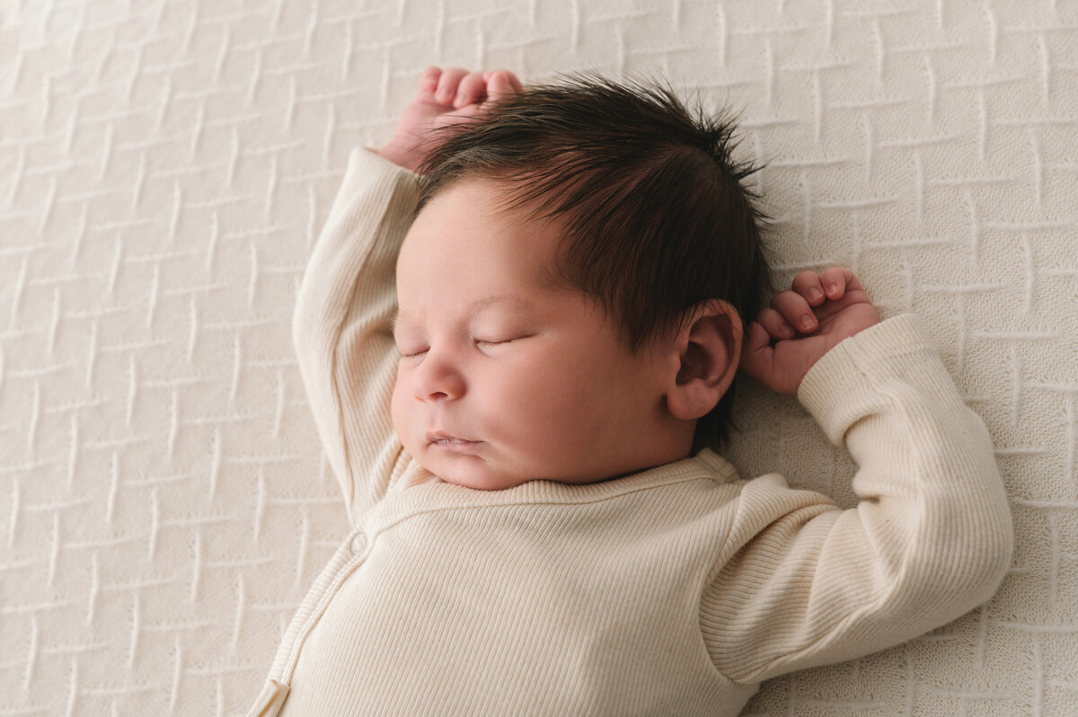 pasgeboren baby jongen in neutrale setting met uitgestrekte armpjes