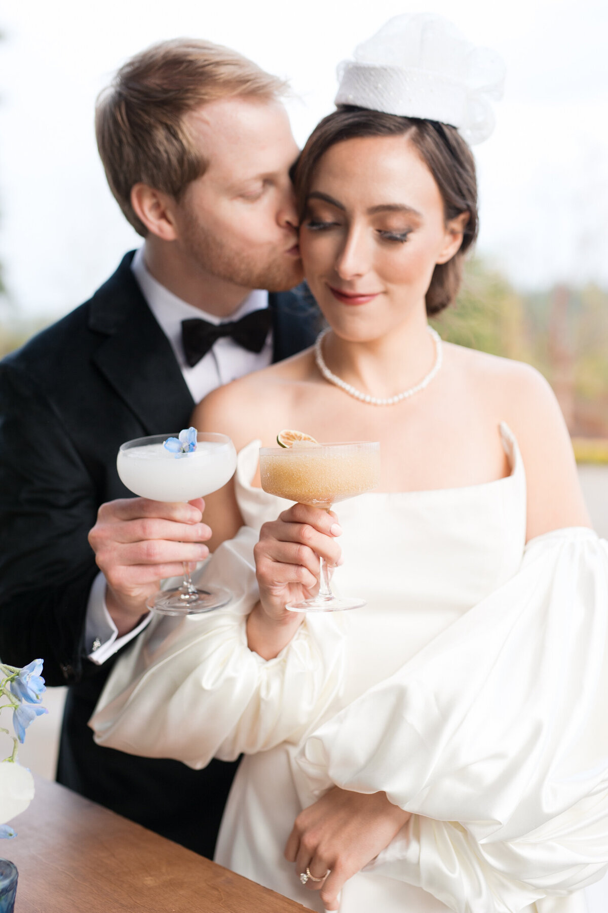 bride and groom holding cocktail glasses from sip and social slushie cart at chateau de lis