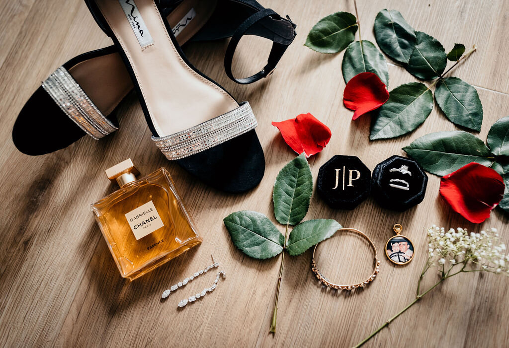 Detail shot of wedding rings, bride's shoes, and perfume at a spring wedding at the Palm Event Center in Pleasanton, CA.