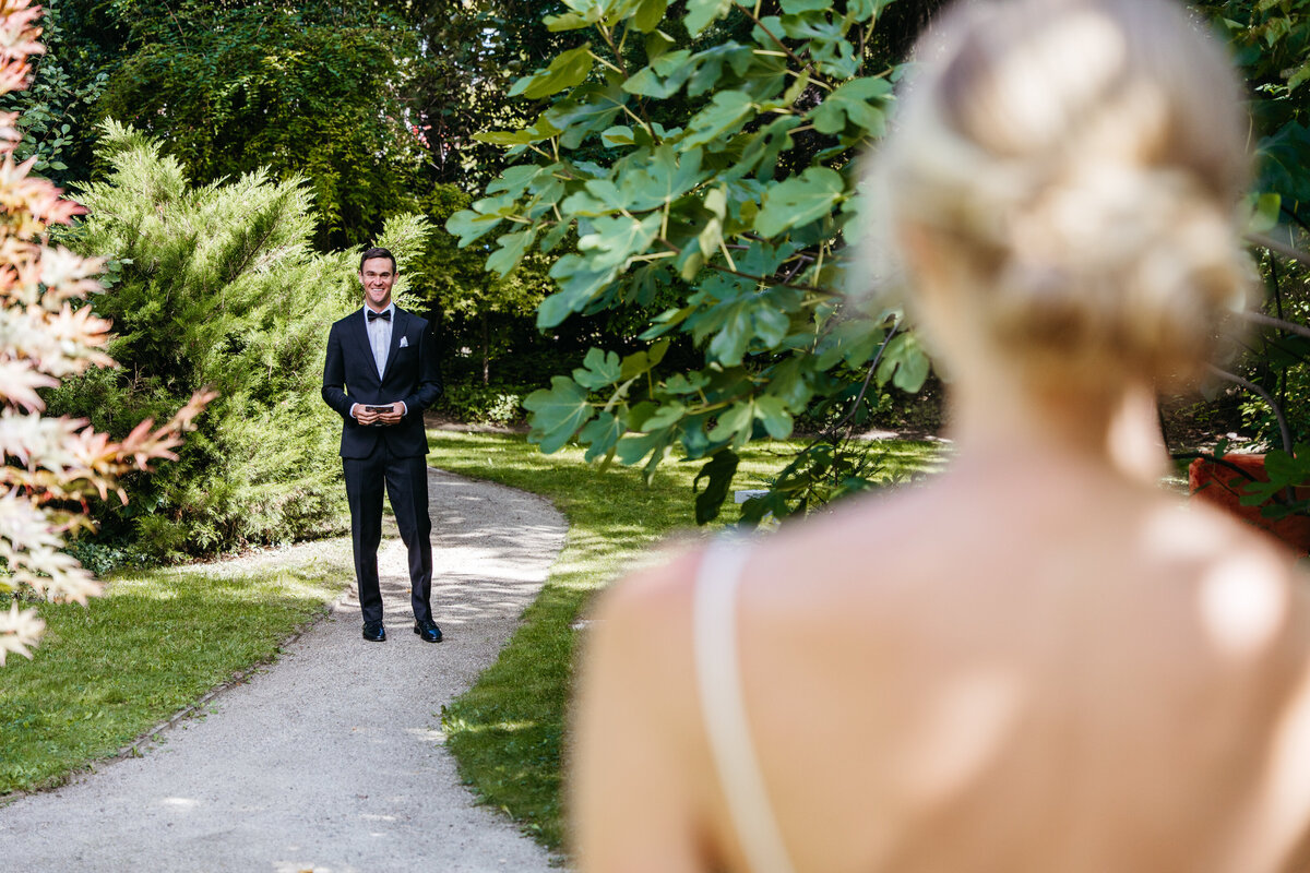 Groom waiting on garden path for first look