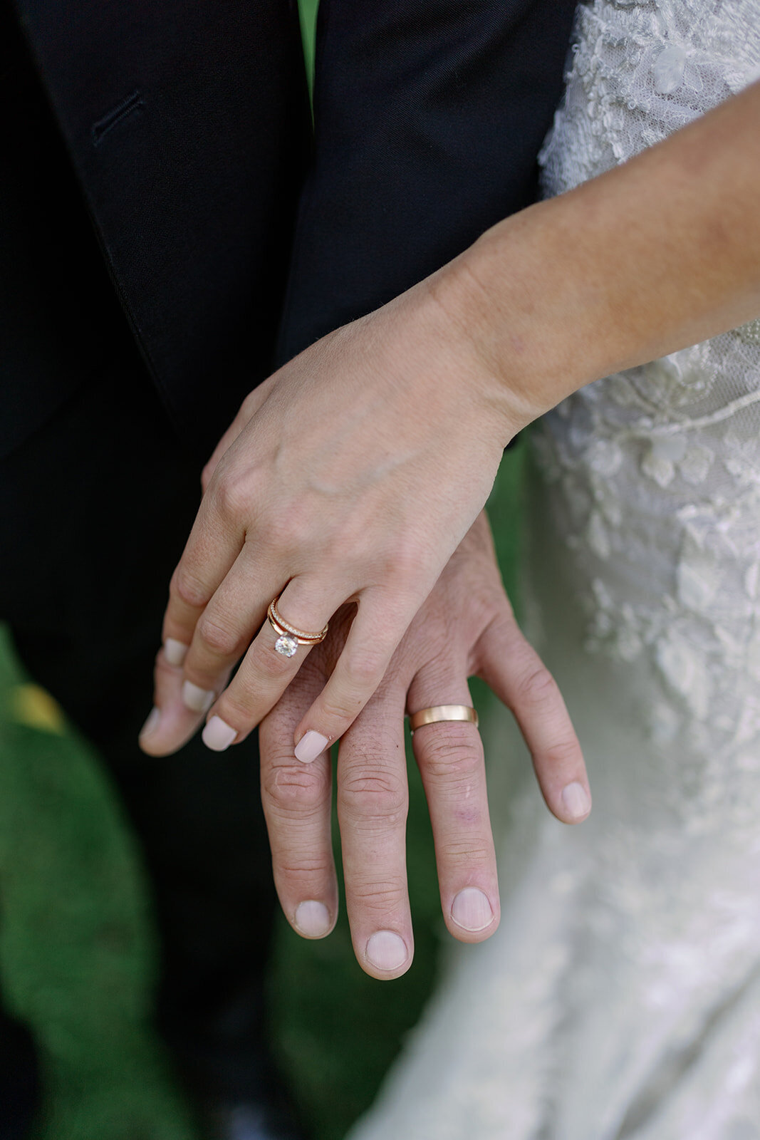 Close-up photo of bride and groom’s wedding rings taken during portraits at Glasshouse Community in Ottawa County.