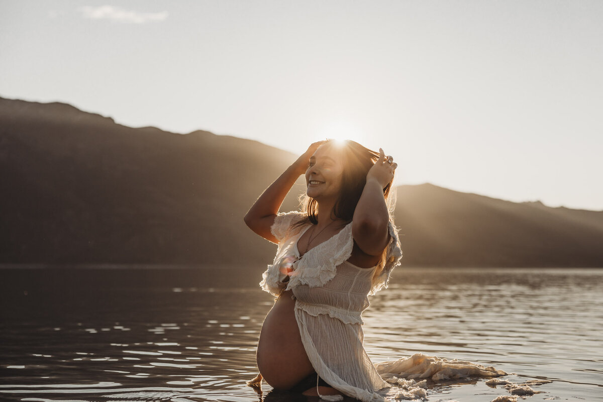 pregnant woman standing in the lake during her maternity session