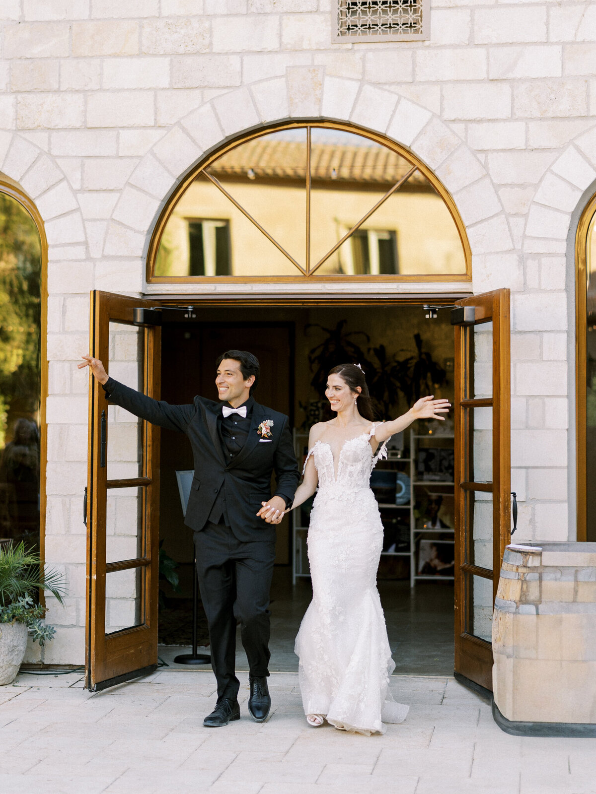 Newlyweds make a grand entrance full of joy and celebration—captured at their elegant Allegretto Vineyard wedding.