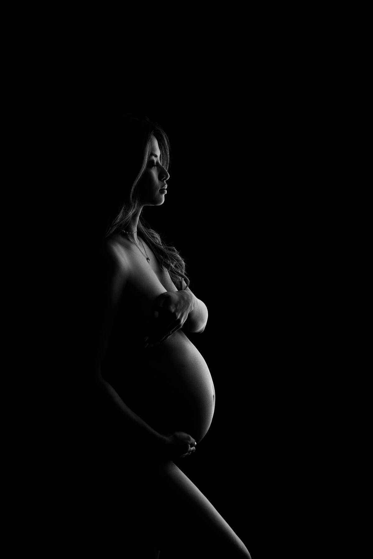 Maternity photos captured by top London, ON Maternity Photographer Amy Perrin-Ogg.  Black and white side profile image of woman.