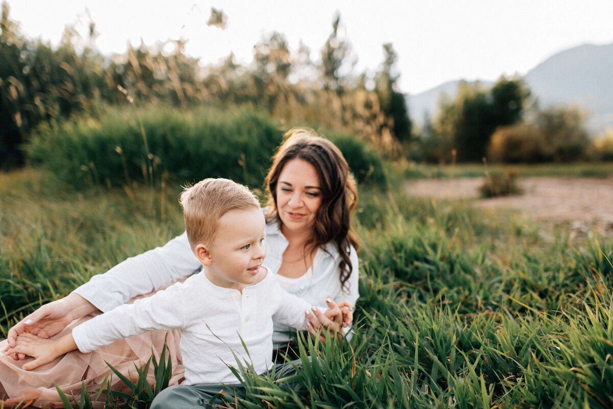 family of two lying in the grass in the mountains