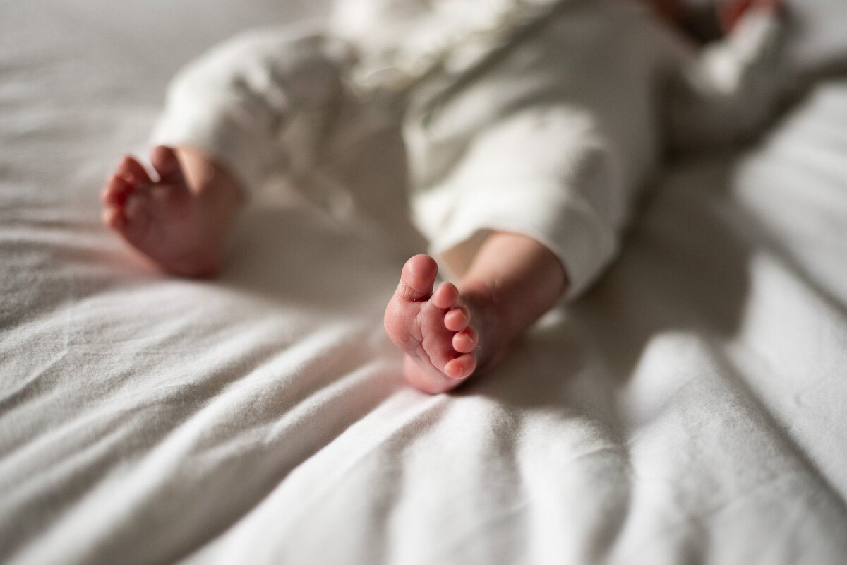 Photo of newborn babies feet on white blanket by newborn photographer Portland Or.
