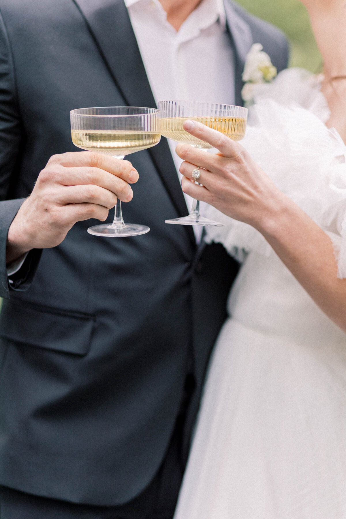 maple grove estate wedding with bride and groom holding champagne glasses while smiling at one another