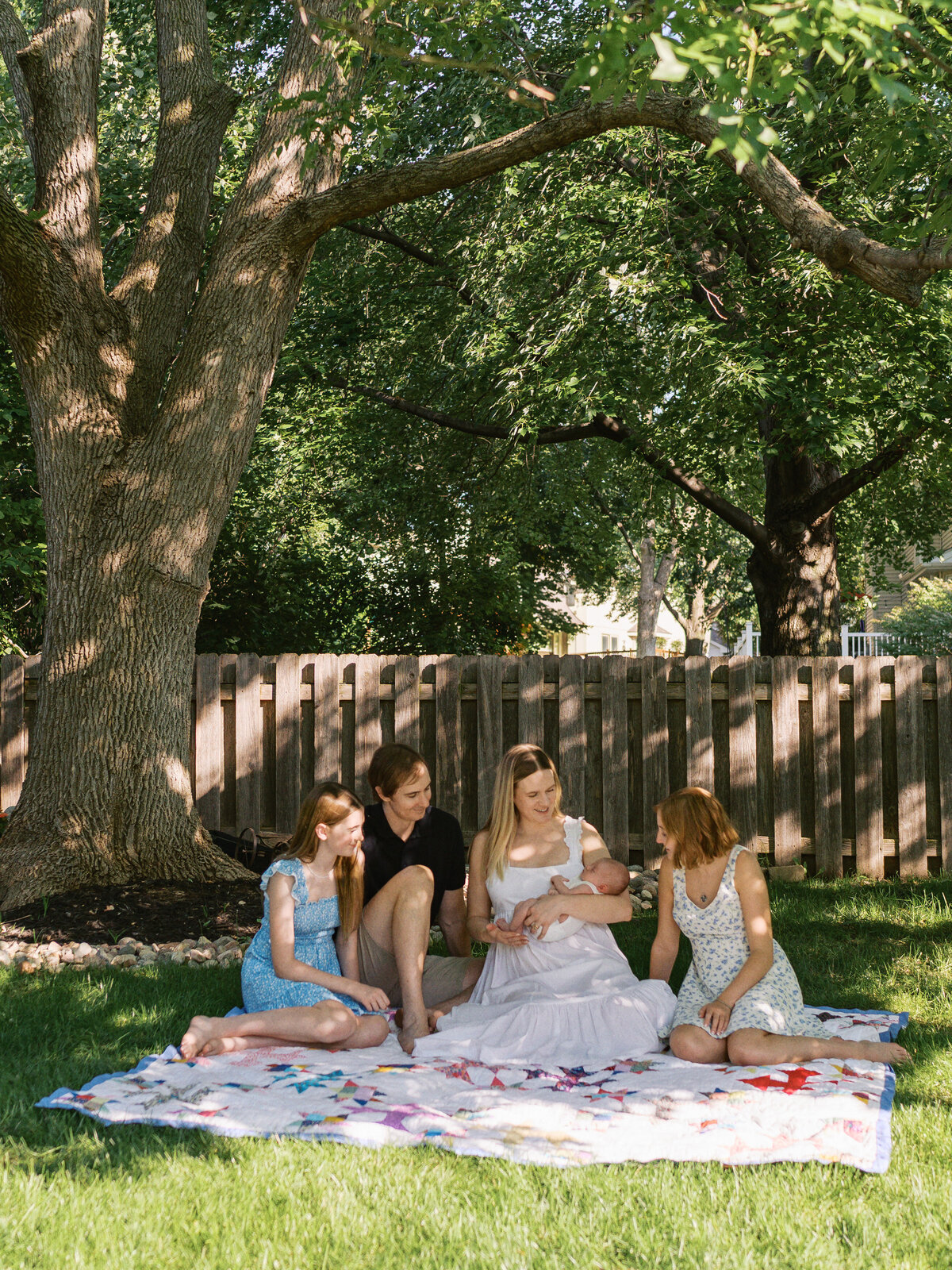 family-looking-at-baby-under-tree