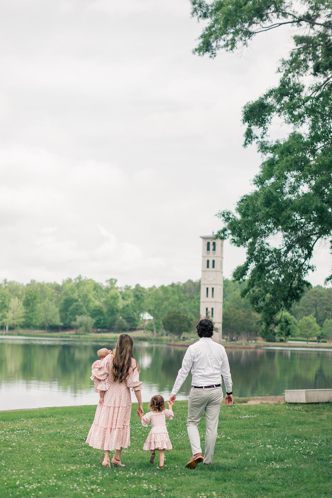 Parents walking with two daughters by lake in SC