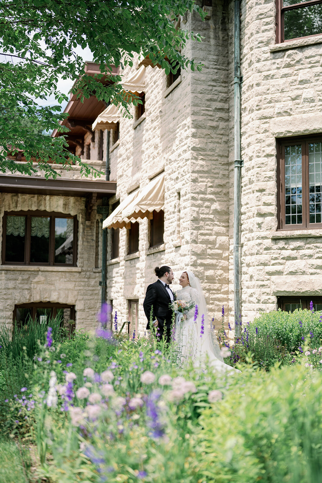 Bride and groom walking through the rose gardens at Henry Ford Estate, captured by a Michigan wedding photographer.