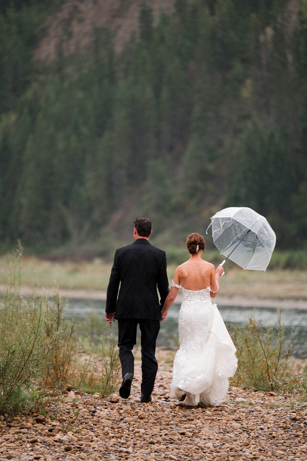 Bride and groom hold hands and walk on the river bed