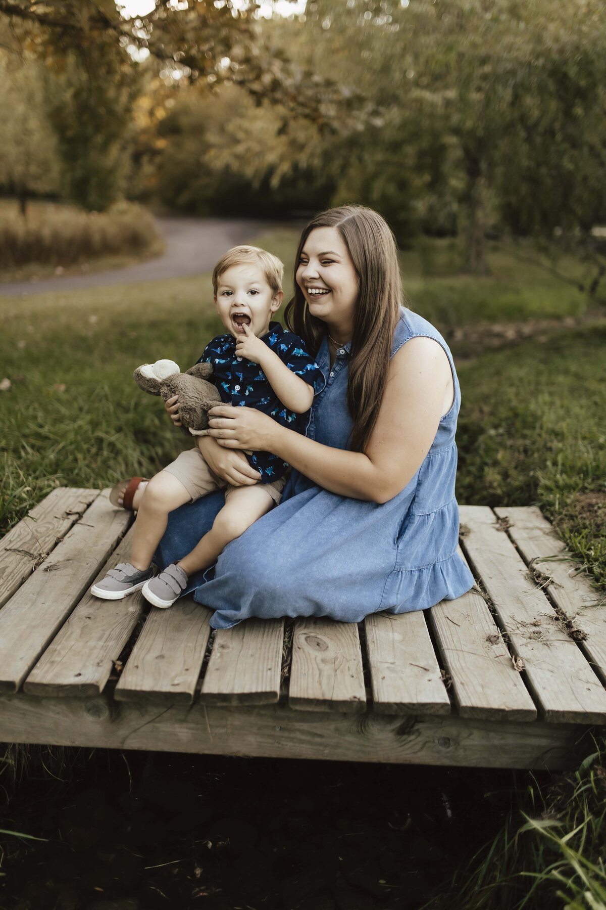 Sweet and silly mother and son moment on bridge in park near Marshfield Missouri