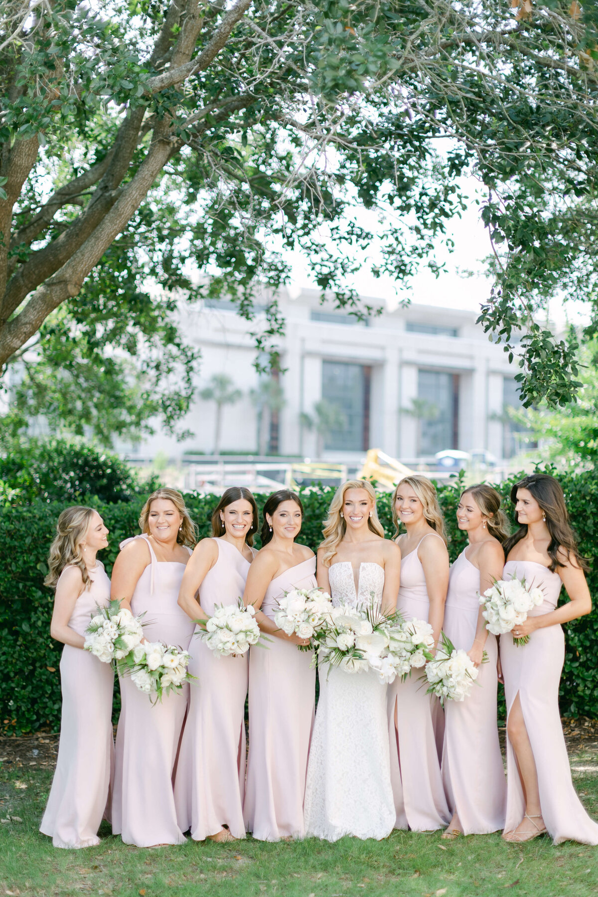 A bride holding florals with her bridesmaids.