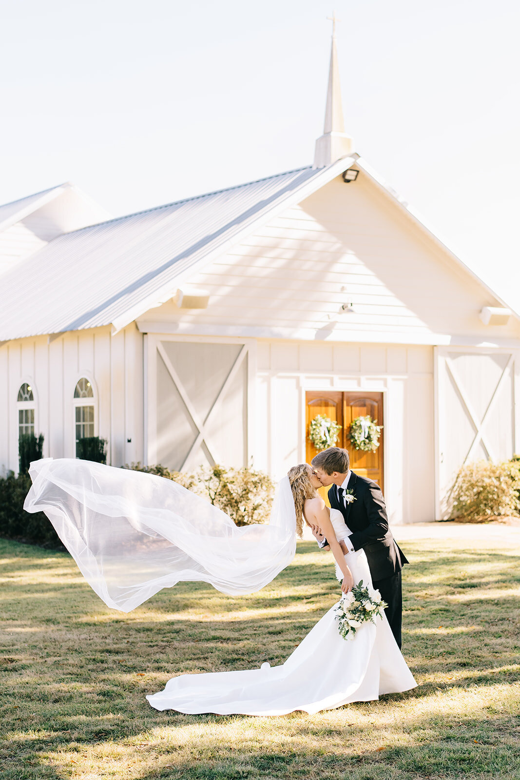 Bride and groom with white and green floral bouquet designed by Abby Grace Florals at Saluda SC wedding