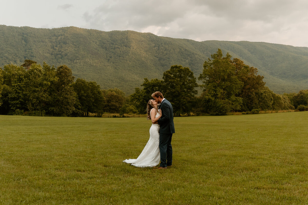 Bride and groom kissing in front of  beautiful Unaka mountain background scene at Mountain Shadow Farm, Greeneville, TN