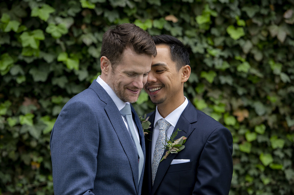 A newlywed couple standing close together smiling 