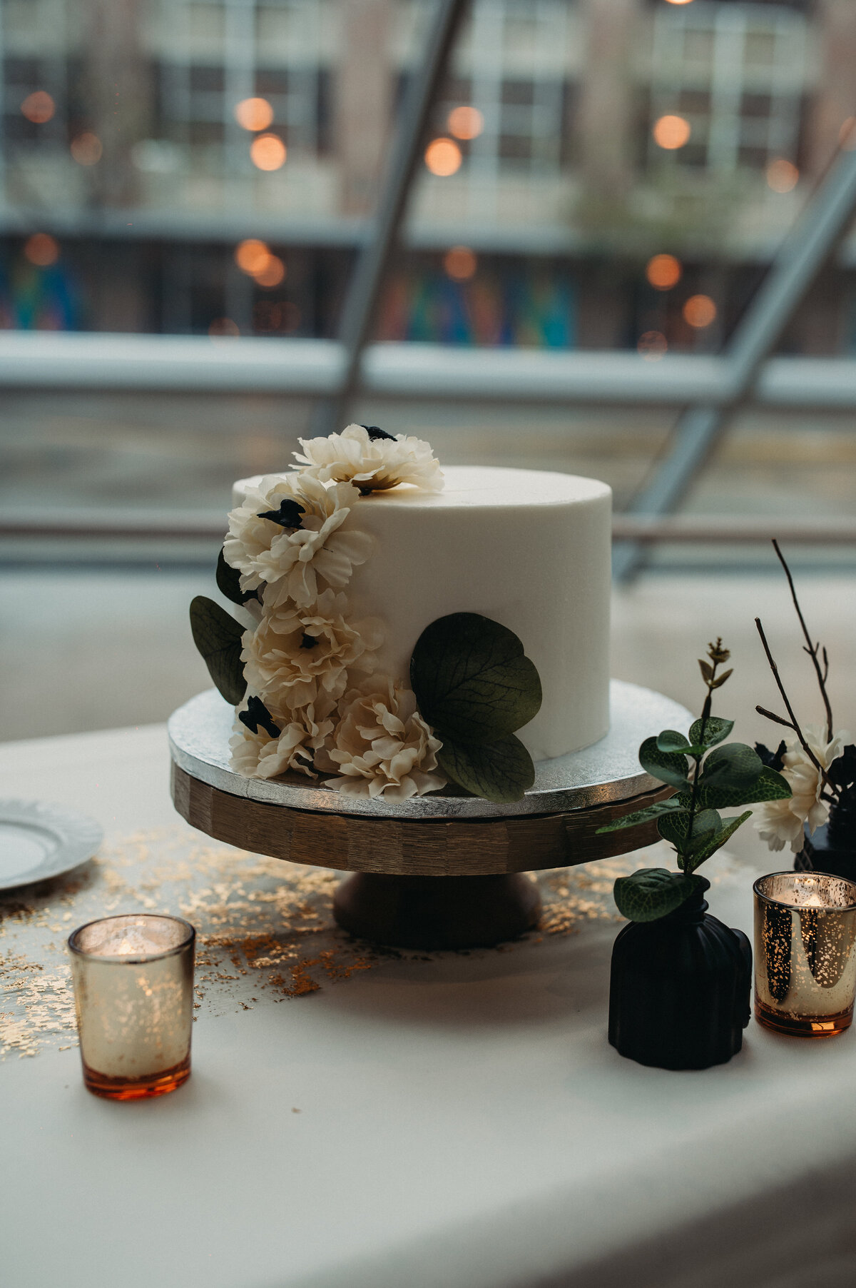 Small black crows hide in white flowers on this minamilistic wedding cake,