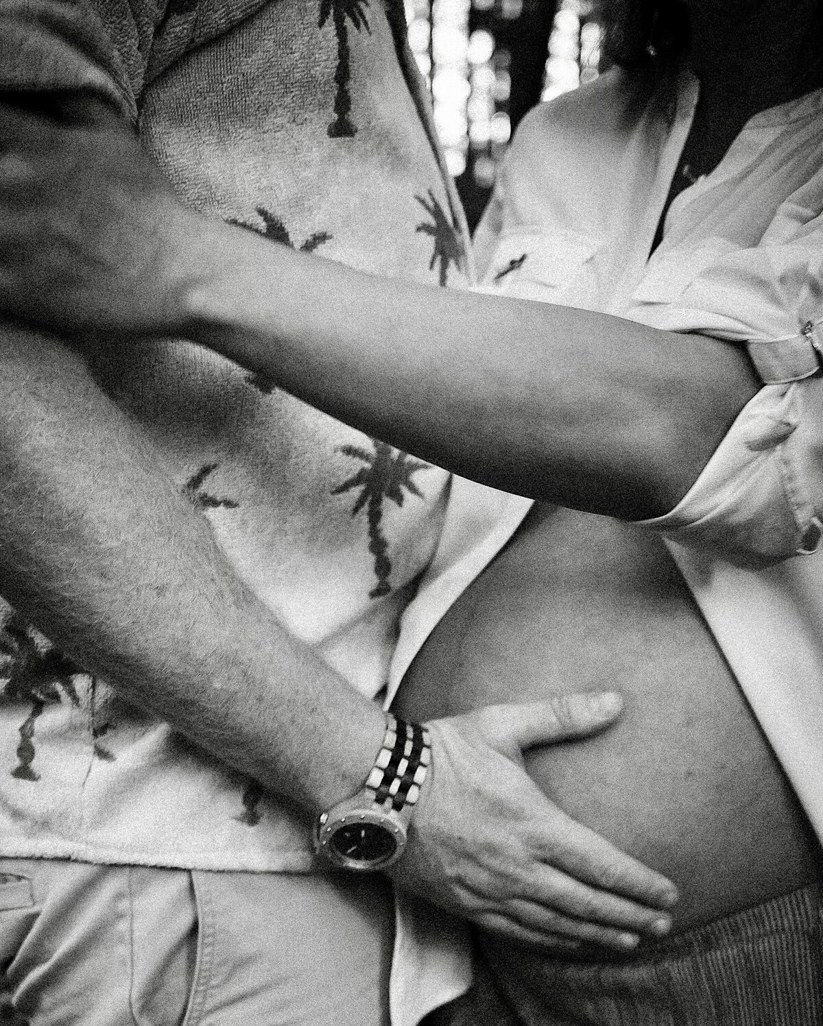 Close up image of pregnant belly and partner's hands