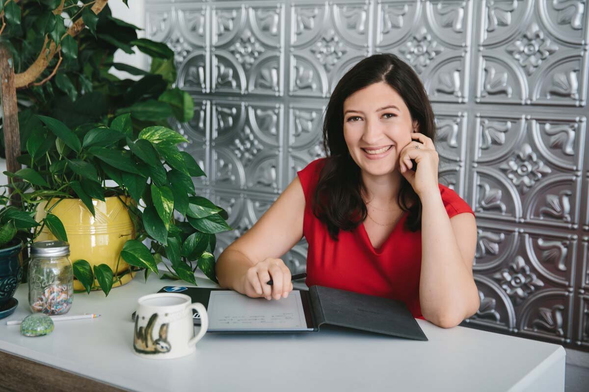 Woman sitting at desk and smiling for branding portrat