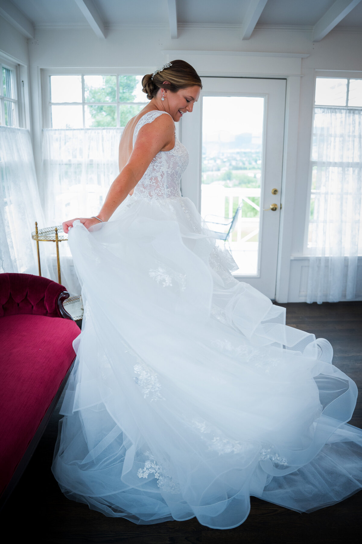 A bride twirls in her wedding dress and smiles, captured by Denver wedding photographer, Casey Van Horn.