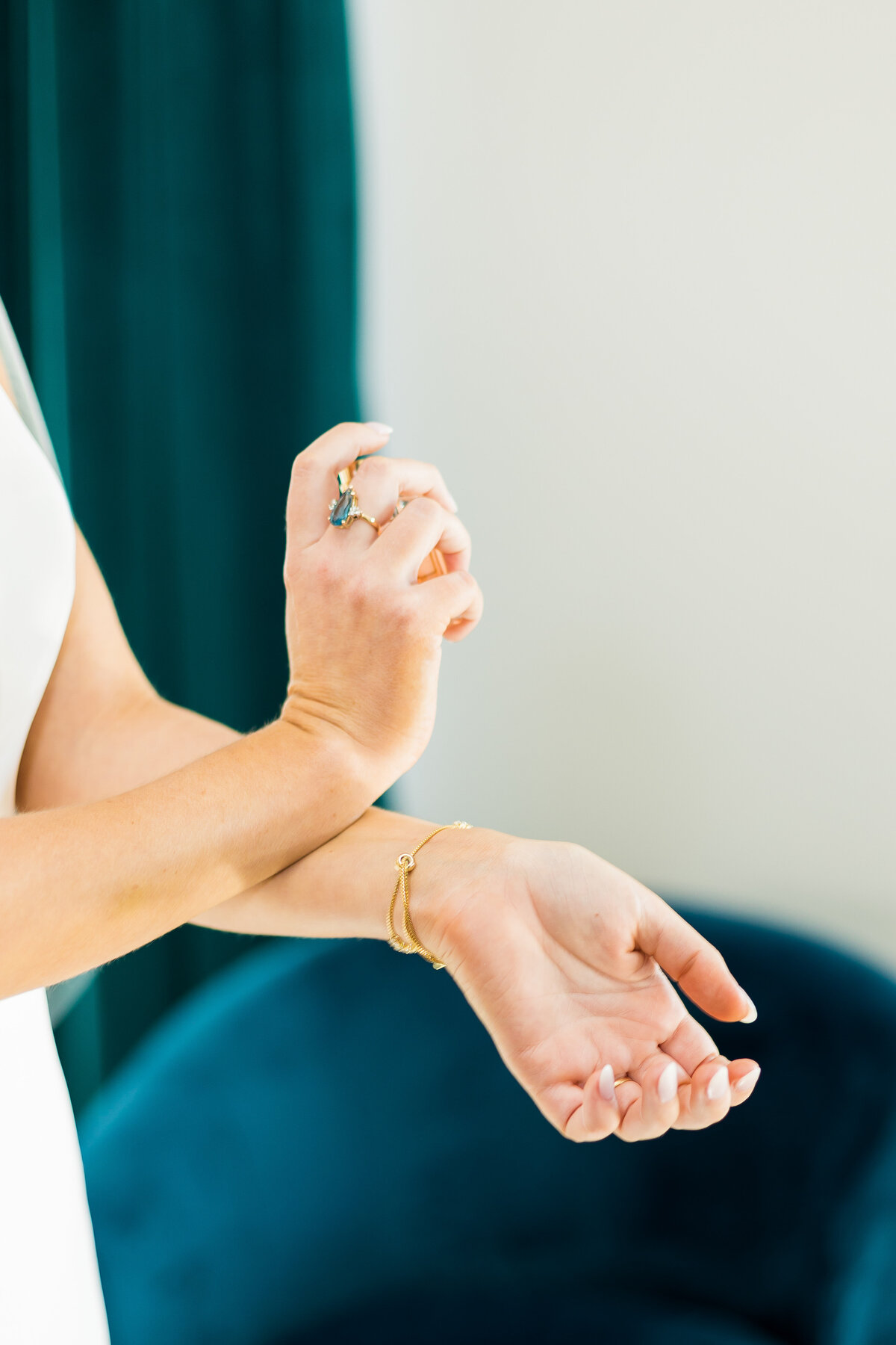 Bride dabbing perfume on her wrists